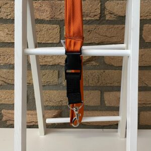 Oranje keycord, een helder en duurzaam accessoire gemaakt door upcycling, perfect voor het dragen van sleutels of ID-kaarten.