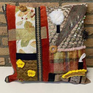 Zacht dementie kussen met verschillende texturen en speelse elementen, ontworpen om rust te bieden en zintuiglijke prikkels te stimuleren voor mensen met dementie.